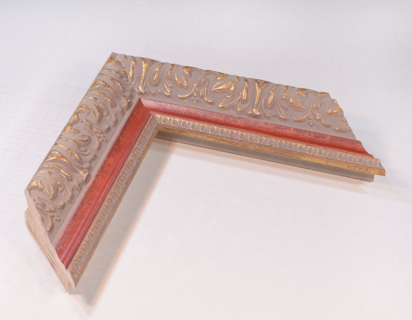 Antique gold picture frame on grey pink background with red stripe in classic style. 2.13" wide x 1.34" high.